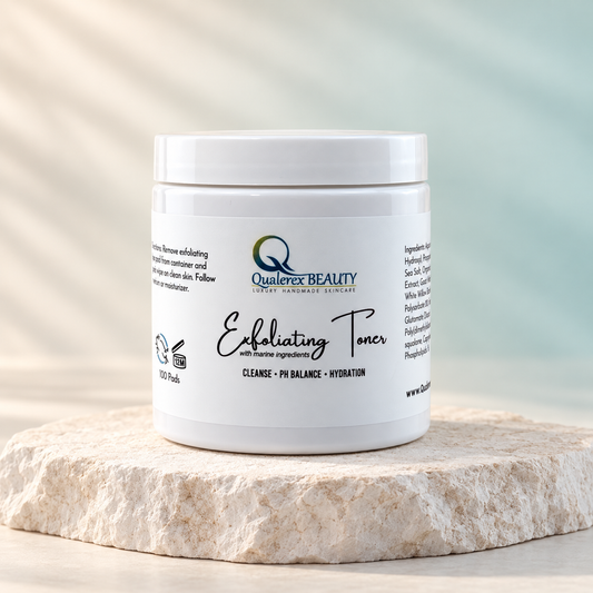 Jar of Qualerex Beauty Exfoliating Facial Toner Pads on a light stone pedestal.
